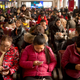 Passengers use their smartphones as they sit in a waiting room at the Beijing Railway Station.